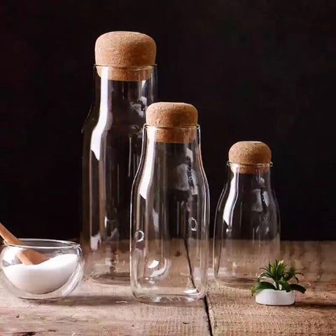 Three sizes of glass jars with cork stopper lids