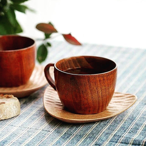 Wood cup with a handle on a small wood plate